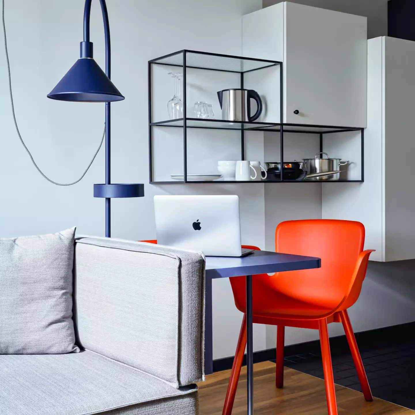 Laptop workstation in front of a shelf and next to a sofa in the Stayery Bielefeld