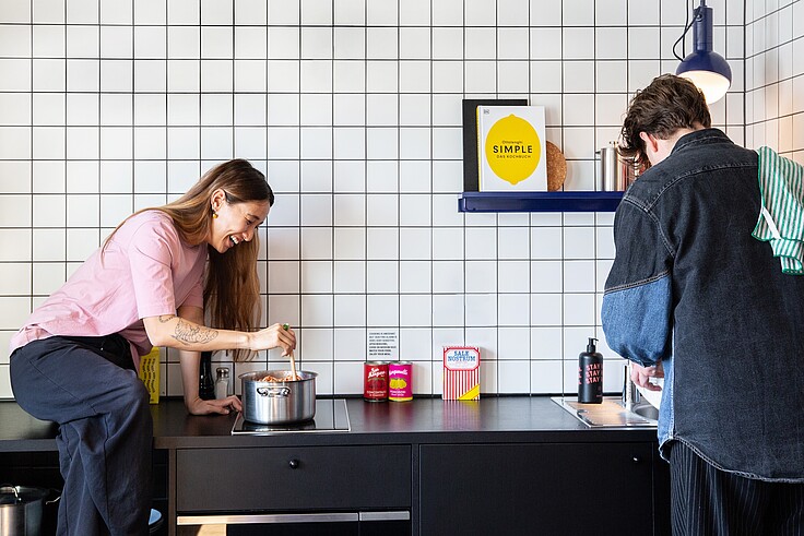 Zwei Personen in der Küche eines STAYERY Apartments kochen zusammen