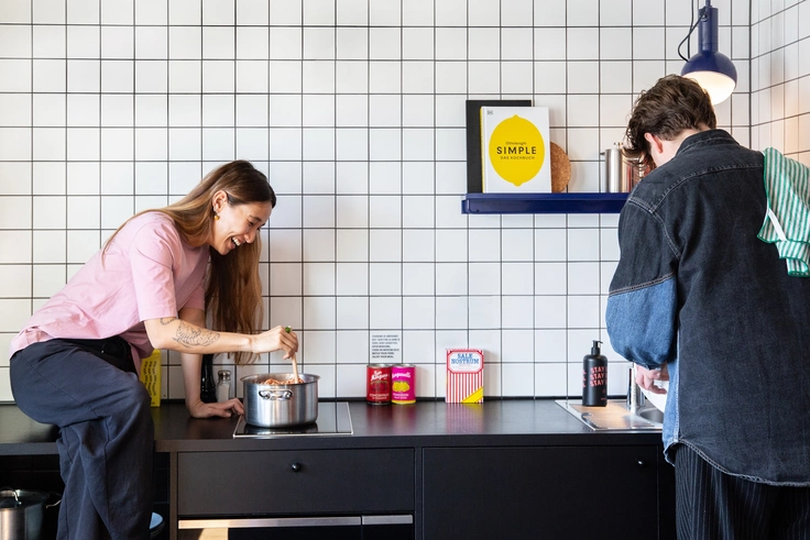 Zwei Personen in der Küche eines STAYERY Apartments kochen zusammen