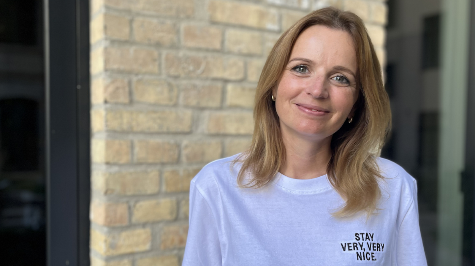 Eine Mitarbeiterin der Stayery namens Kirsten in einem weißen Stayery-T-Shirt