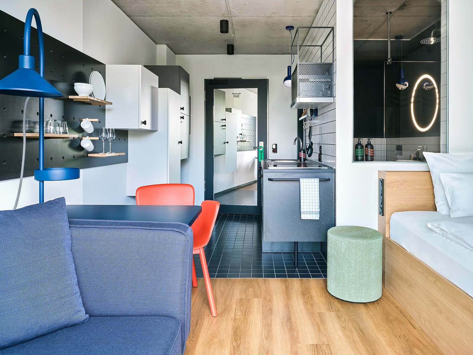 Einblick in eines der Apartments in der Stayery Frankfurt mit Bett, Sofa und Küchenzeile