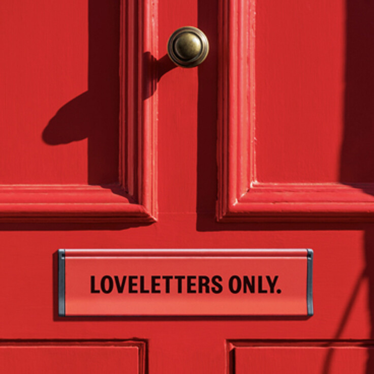 Rote Tür mit Briefschlitz und Aufschrift Loveletters only