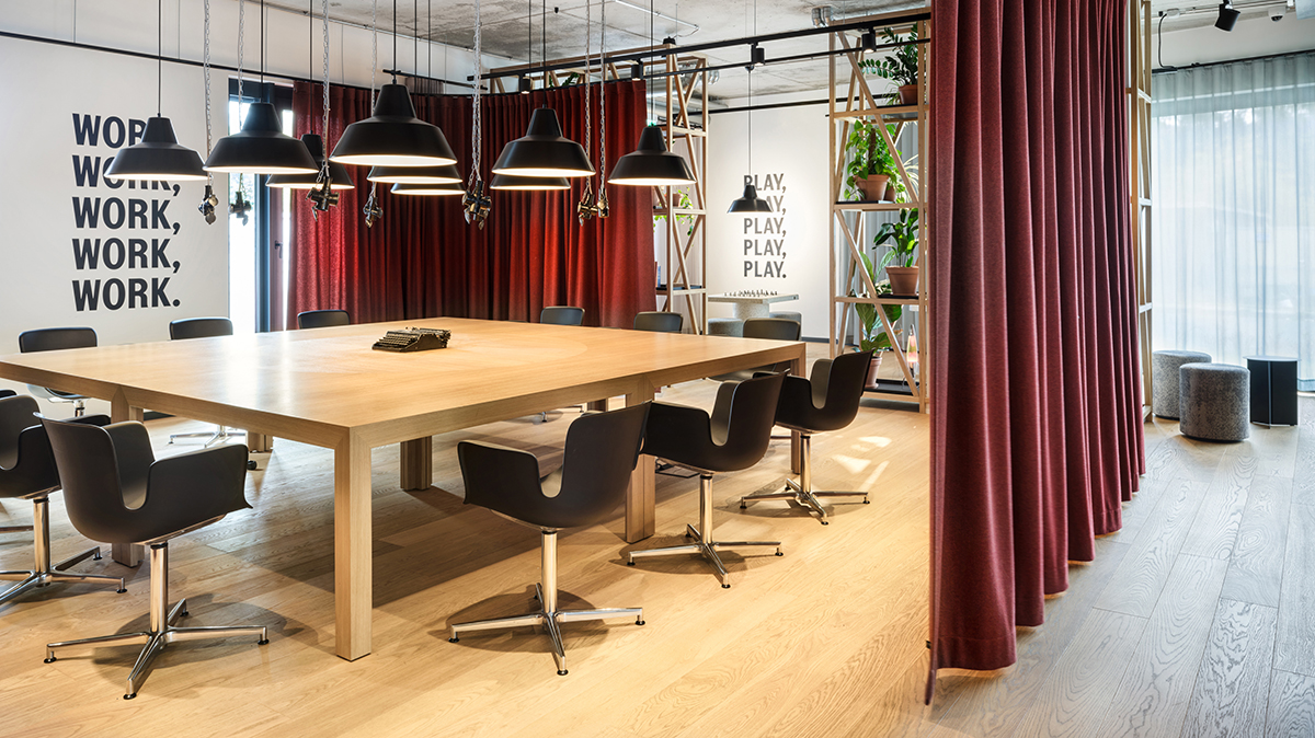 Coworking-Bereich mit großem Tisch und Vorhang